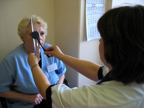 Õde-ortoptist Maimu Kask demonstreerib kolleegi peal prismadega kinnikatmistesti teostamist. Foto: silmakliiniku erakogu.